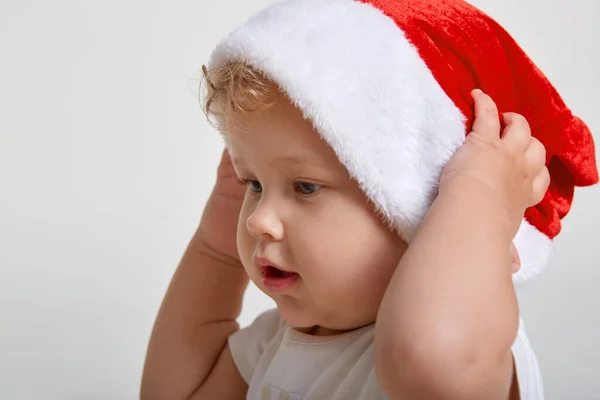 Bonito Menino Caucasiano Colocando Chapéu Papai Noel Contra Fundo Branco — Fotografia de Stock
