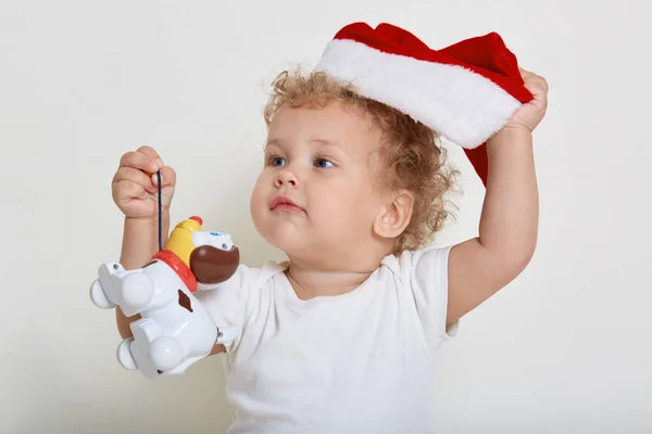 Счастливый Малыш Шляпе Санта Играть Игрушкой Глядя Сторону Положить Шляпу — стоковое фото