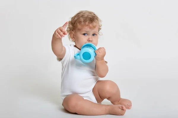 Retrato Bebê Bonito Bebendo Água Copo Garrafa Azul Indicando Afastado — Fotografia de Stock