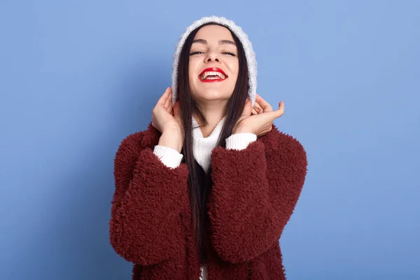 Menina Cabelos Escuros Coloca Chapéu Inverno Sobre Fundo Azul Isolado — Fotografia de Stock