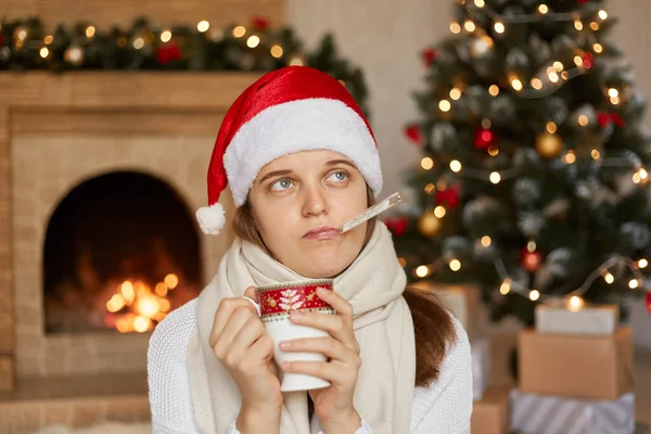 Sjuk Flicka Santa Hatt Mäta Temperaturen Medan Håller Kopp Uppvärmningen — Stockfoto