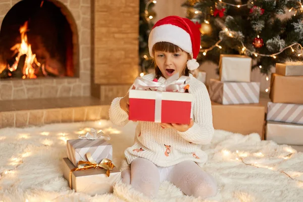 Menina Surpreendida Vestindo Chapéu Papai Noel Suéter Quente Branco Sentado — Fotografia de Stock