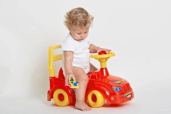 Μικρό Αγόρι Κάθεται Κόκκινο Αυτοκίνητο Παιχνίδι Και Κρατώντας Μικροσκοπικό Όχημα — Φωτογραφία Αρχείου