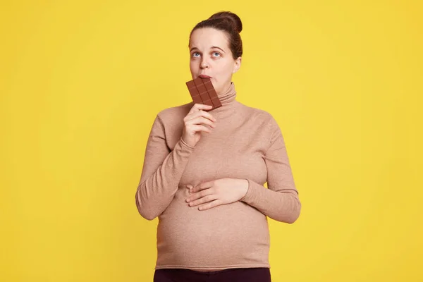 Satisfecho Embarazada Mordiendo Barra Chocolate Mirando Hacia Arriba Siendo Duda — Foto de Stock