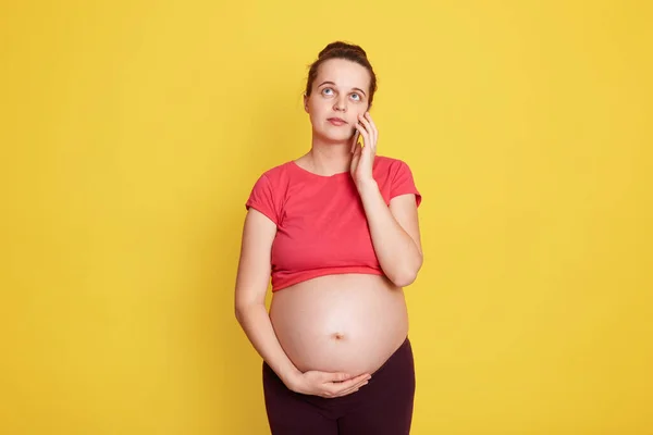 Lachende Zwangere Vrouw Praten Haar Smartphone Terwijl Poseren Geïsoleerd Gele — Stockfoto