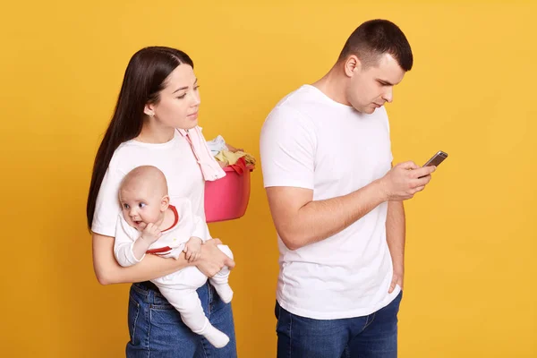 Žárlivá Žena Špehuje Telefon Svého Partnera Který Ním Pózuje Novorozeným — Stock fotografie