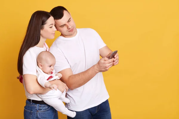 Mladá Rodina Usmívá Při Pohledu Obrazovku Chytrého Telefonu Manžel Ukazuje — Stock fotografie