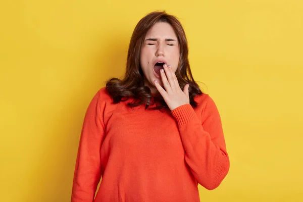 Hermosa Mujer Bosteza Aislado Sobre Fondo Amarillo Vistiendo Jersey Naranja — Foto de Stock