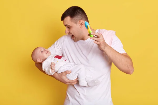 Young Caucasian Father Playing Rattle Toy Calming Baby Isolated Yellow — Stock Photo, Image