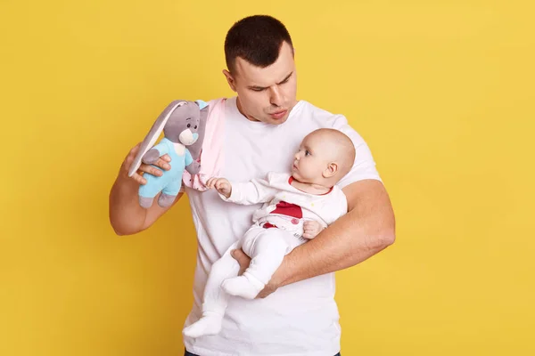 Young Concentrated Male Wearing White Shirt Calms Her Newborn Child — Stock Photo, Image
