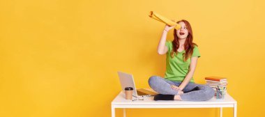 Oyuncu genç bir kadın ya da öğrenci bacak bacak üstüne atmış, kağıt büküyor, dürbün gibi yukarı bakıyor, ağzını açık tutuyor, ilginç bir şey görüyor, reklam için boşluk kopyalıyor..