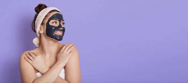 Lachende Jonge Volwassen Vrouw Haarband Met Zwart Gezichtsmasker Doen Cosmetologie — Stockfoto