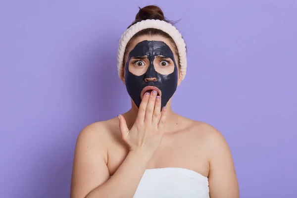 Geschokt Vrouwtje Met Zwarte Hydraterende Masker Gezicht Met Open Mond — Stockfoto