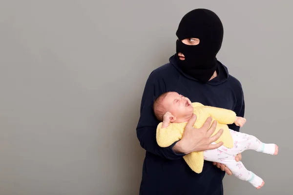 Man Thief Balaclava Kidnapped Newborn Crying Baby Runs Away Looks — Stok fotoğraf