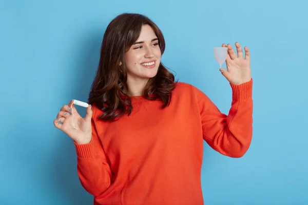 Smiling Dark Haired Young Adult Woman Wearing Orange Jumper Holding — Stok Foto