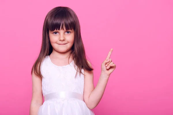 Carino Sorridente Bambina Che Indica Indice Bianco Mentre Guarda Fotocamera — Foto Stock