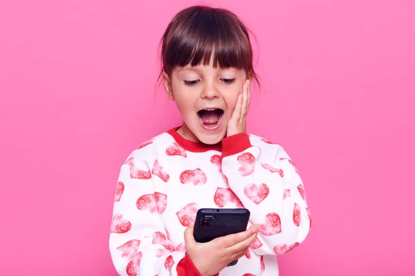 Gembira Anak Perempuan Dalam Gaya Kasual Sweater Memegang Ponsel Pintar — Stok Foto
