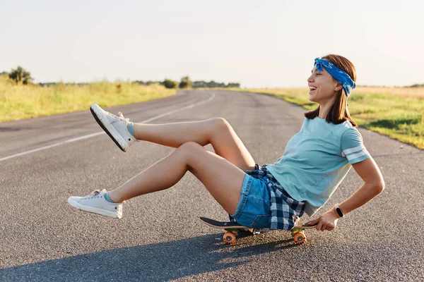 Vista Lateral Mulher Emotiva Feliz Sentada Skate Rua Com Pernas — Fotografia de Stock