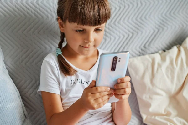 Caucasian Little Girl Sitting Sofa Mobile Phone Hands Dark Haired — Stock Photo, Image