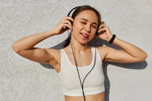 Wanita Muda Cantik Dalam Pakaian Olahraga Dengan Headphone Mendengarkan Musik — Stok Foto