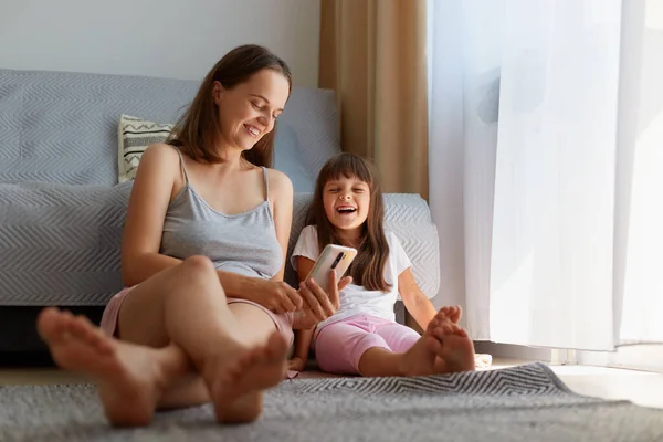 Smiling Female Sitting Floor Sofa Her Cute Dark Haired Daughter — Stock Photo, Image