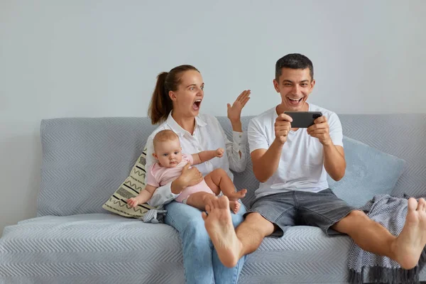 Indoor Shot Excited Family Sitting Sofa Living Room Husband Holding — Stock Photo, Image