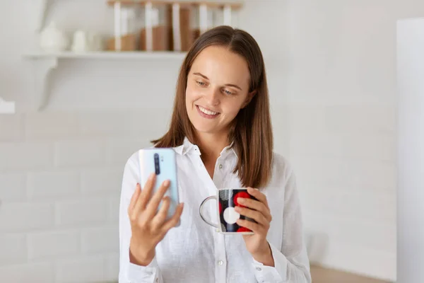 Smiling Woman Posing Light Kitchen Using Smart Phone While Drinking — Stock Photo, Image