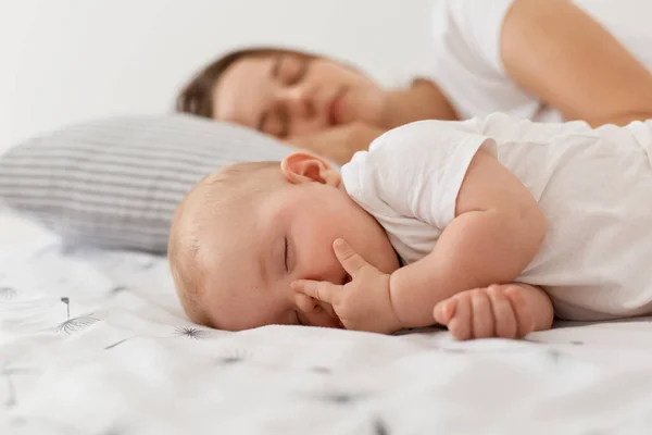 母と彼女の小さな赤ちゃんの肖像画一緒にベッドで寝て 魅力的な娘とともに彼女のお母さんリラックスして休んで 幸せな子供時代と母親 — ストック写真