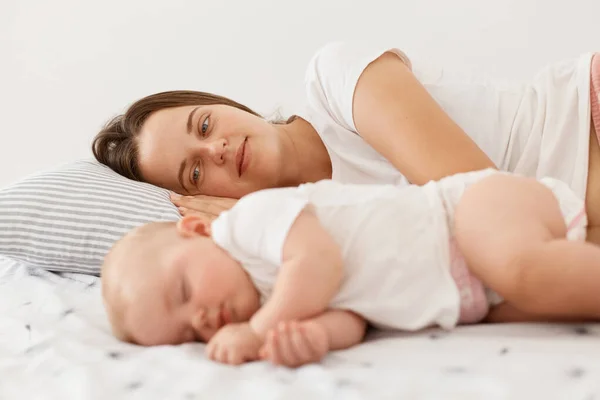 Indoor Shot Young Adult Mother Lying Her Sleeping Baby Looking — Foto de Stock