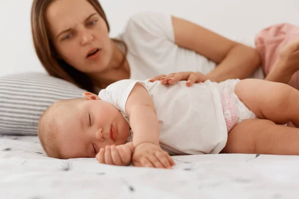Retrato Madre Asustada Preocupada Mirando Pequeña Hija Dormida Tocando Bebé — Foto de Stock