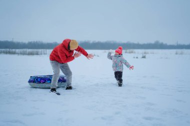 Bir baba soğuk bir kış gününde kızını karda kovalar. Dışarıda eğleniyorlar, gülüyorlar ve açık alanda oynuyorlar..