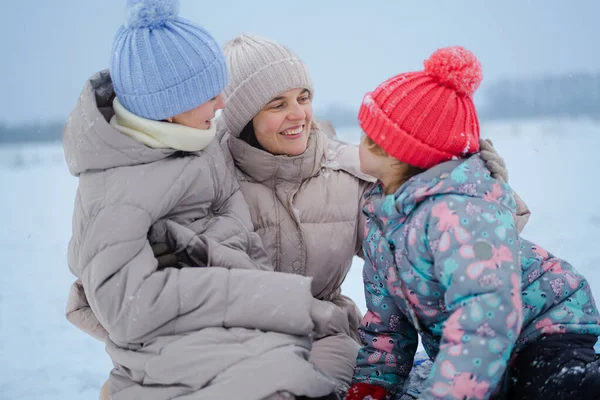 Aile üyeleri karda soğuk bir kış gününün tadını çıkarırlar. Sıcak giyinirler ve karlı bir yüzeyde otururken birbirlerine gülümserler..
