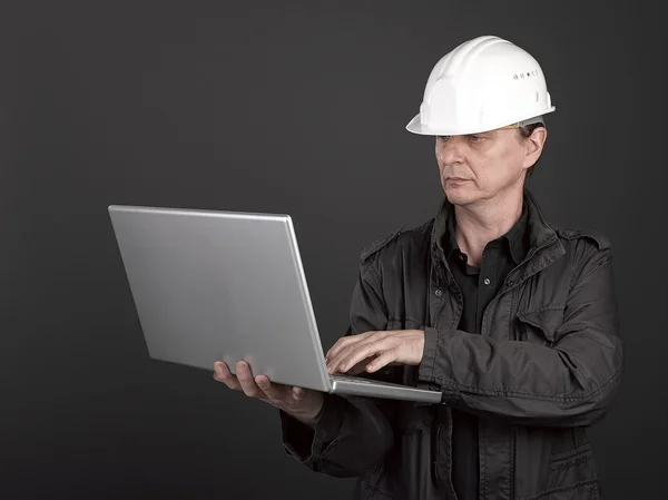 Worker in black shirt and suit holding a laptop — Stock Photo, Image