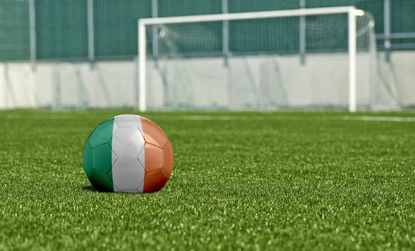 Balón de fútbol en el campo verde- bandera Irlanda — Foto de Stock