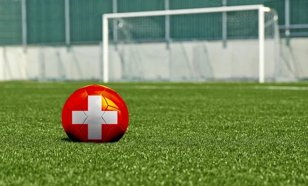 Balón de fútbol en el campo verde- bandera Suiza —  Fotos de Stock