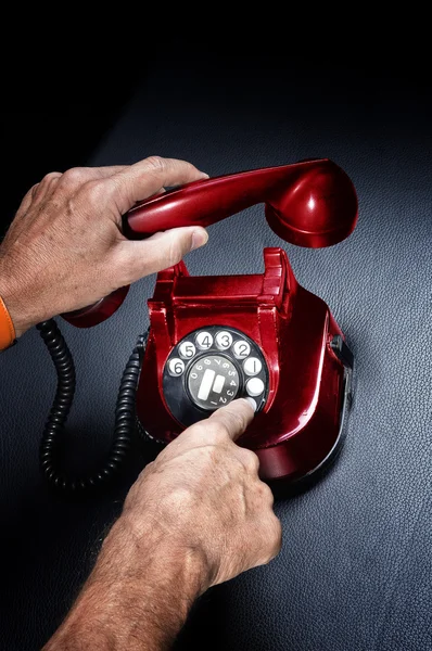 Mannen håller upp vintage röd telefonen — Stockfoto