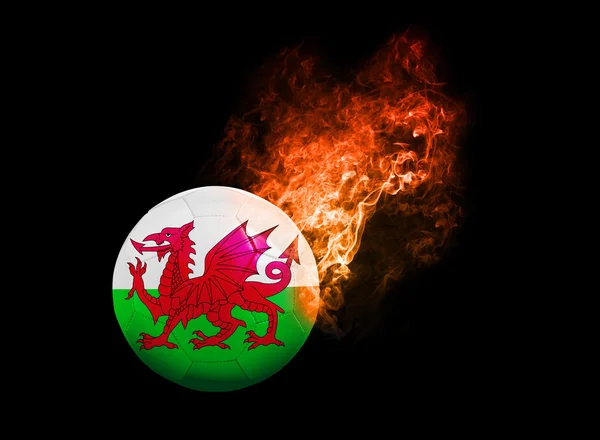 Flaming Voetbal bal op zwarte achtergrond vlag van Wales — Stockfoto