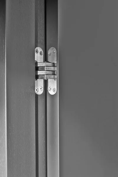 Silver hinge attached to black wooden door — Stock Photo, Image