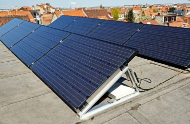 Güneş doğarken çatıda açık mavi gökyüzü olan büyük elektrik panelleri.