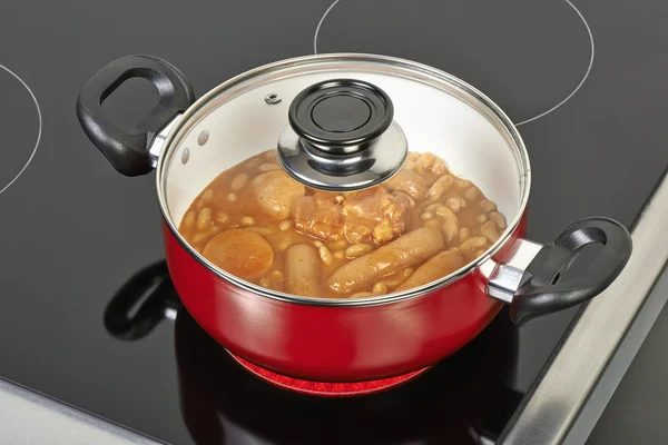 Preparing cassoulet in red ceramic pan — Stock Photo, Image