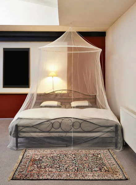 Cosi cama vintage con mosquitero en un loft restaurado —  Fotos de Stock