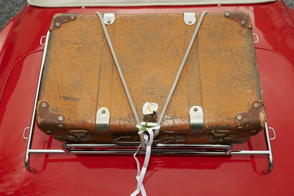 Suitcase placed on the trunk of a red car — Stock Photo, Image