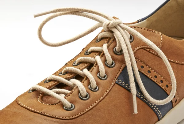 Shoelace em close-up e sapato marrom isolado em branco — Fotografia de Stock