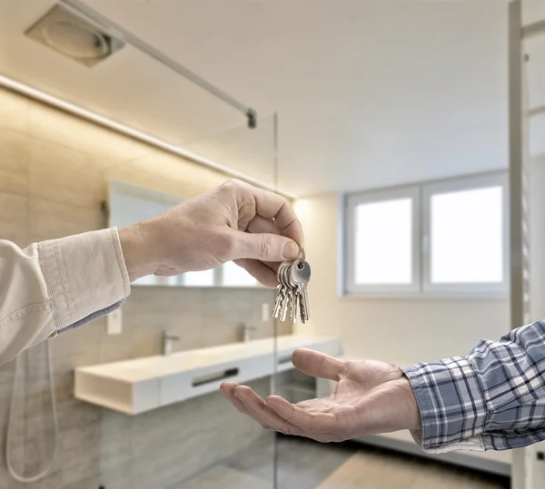 Realtor dando la llave de la casa al comprador en la casa de lujo del cuarto de baño — Foto de Stock