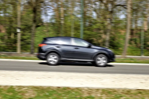 Familienauto fährt durch sommerliche Stadtlandschaft — Stockfoto