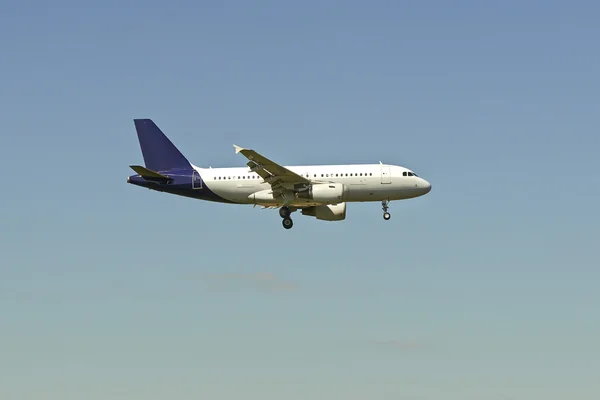 Avião a jato pousando no céu brilhante — Fotografia de Stock