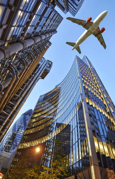 Un avión a reacción sobrevolando la ciudad — Foto de Stock