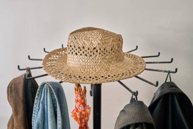 Palto askısı, ceket, beyaz duvara karşı şapka.