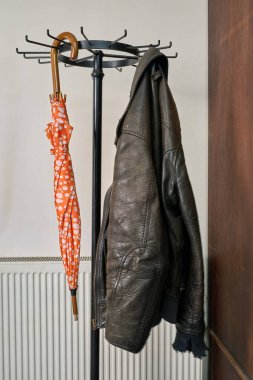 Palto askısı, şemsiye, ceket beyaz duvara karşı