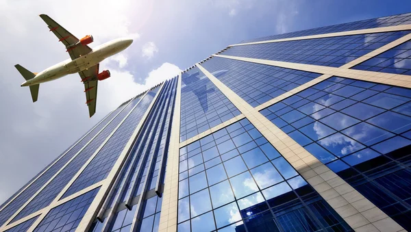 Un avión a reacción volando bajo sobre el edificio de oficinas — Foto de Stock